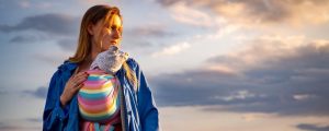 a woman wearing a new baby in a wrap, looking to the sky