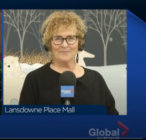 Image of YWCA Executive Director Kim Dolan standing in front of festive polar bear backdrop, wearing headphones