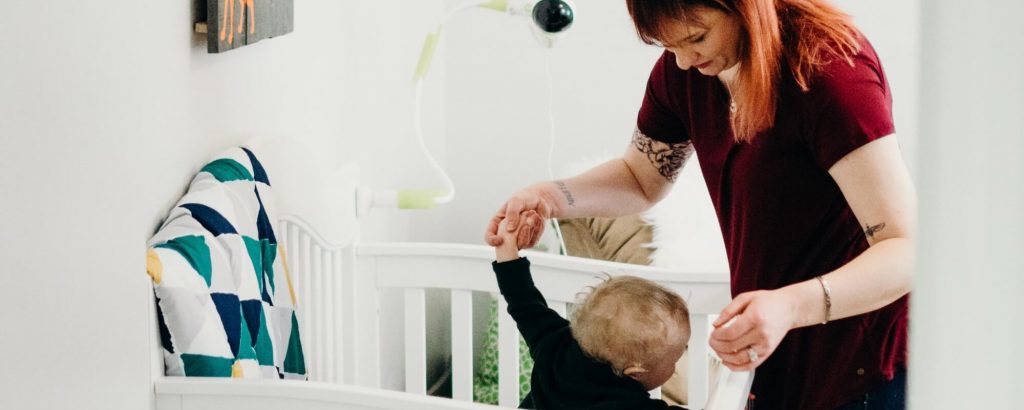 Image of a mother placing a young child into a crib