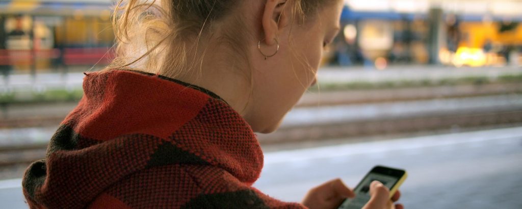 young woman using cell phone outside